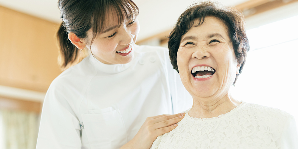 笑顔の高齢女性と理学療法士の女性